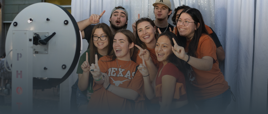 Students doing hookem horns in a photobooth
